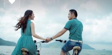 Couple amoureux qui fait du vélo ensemble main dans la main pour symboliser le couple qui se projette ensemble dans l'avenir